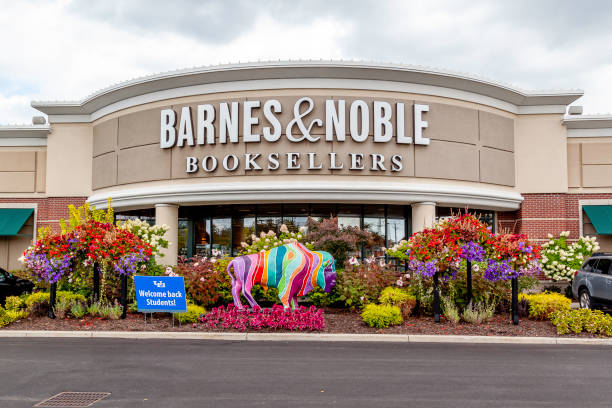 Front of Barnes and Nobles bookstore with vibrant purple and red flowers, a multi-colored statue of a bull, and green shrubs in front of the store